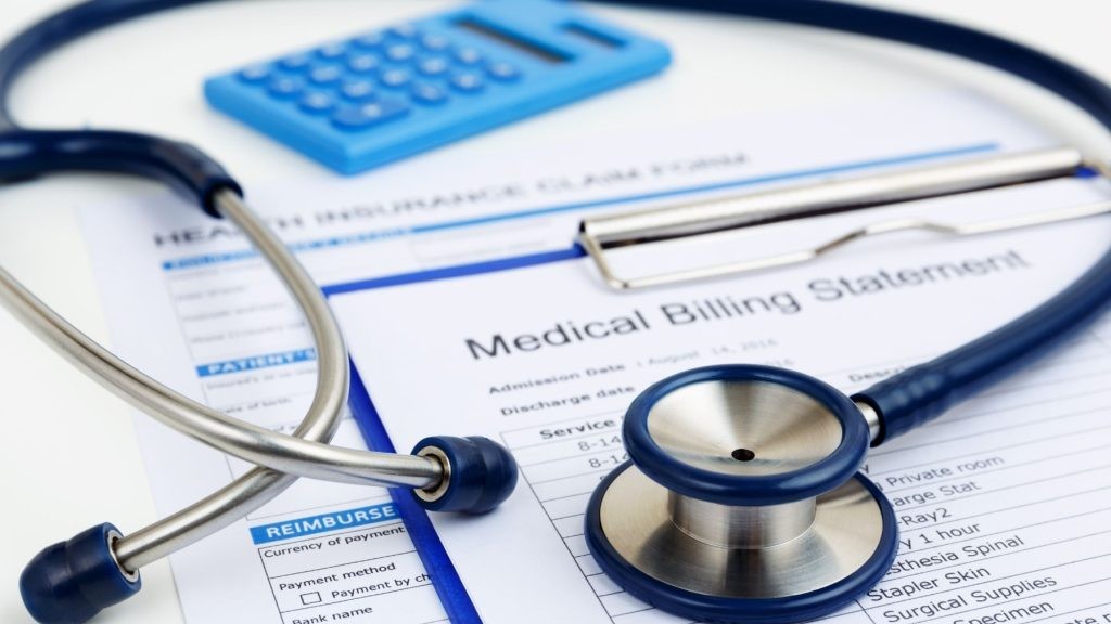 Health insurance claim form, medical billing statement, calculator, and stethoscope for Kansas City RCM services